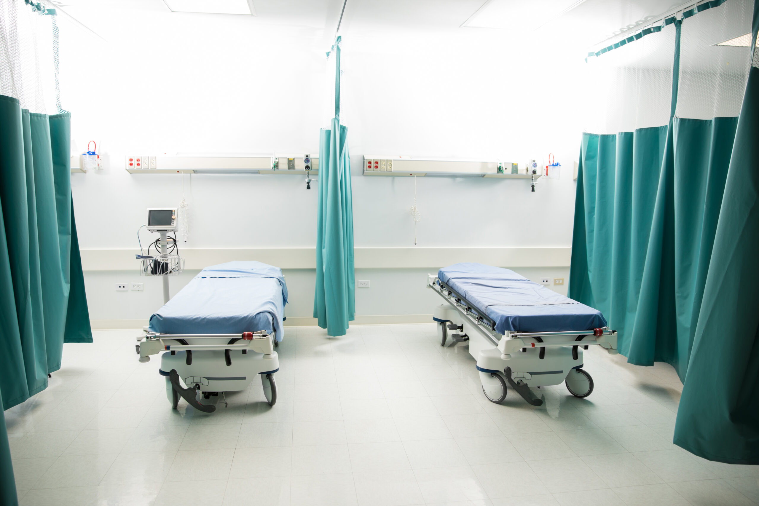 Wide view of a couple of empty beds in an emergency room at a hospital