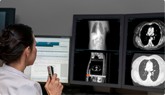 radiologist analyzing AI medical imaging scans on multiple monitors