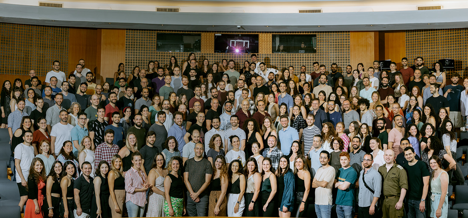 A group of people taking a photo in a auditorium