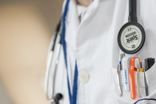 A doctor in uniform with pens in his chest pocket