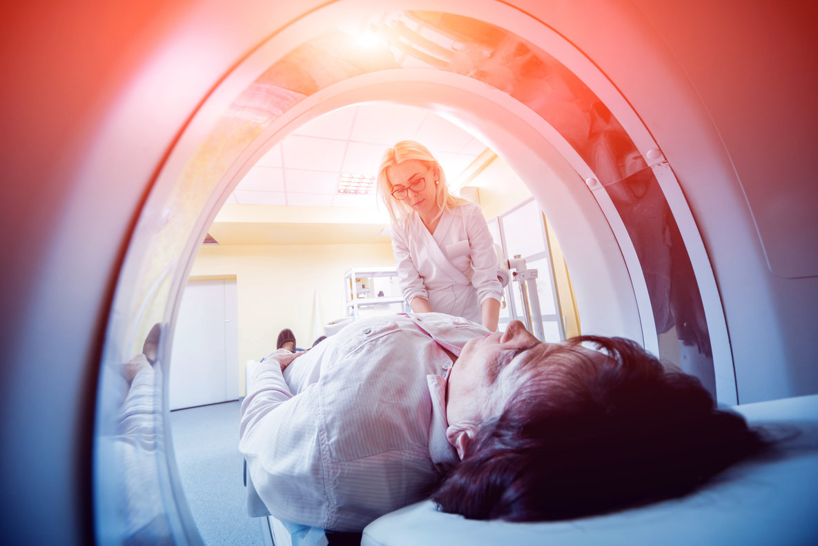 Doctor and patient in the room of computed tomography at hospital.