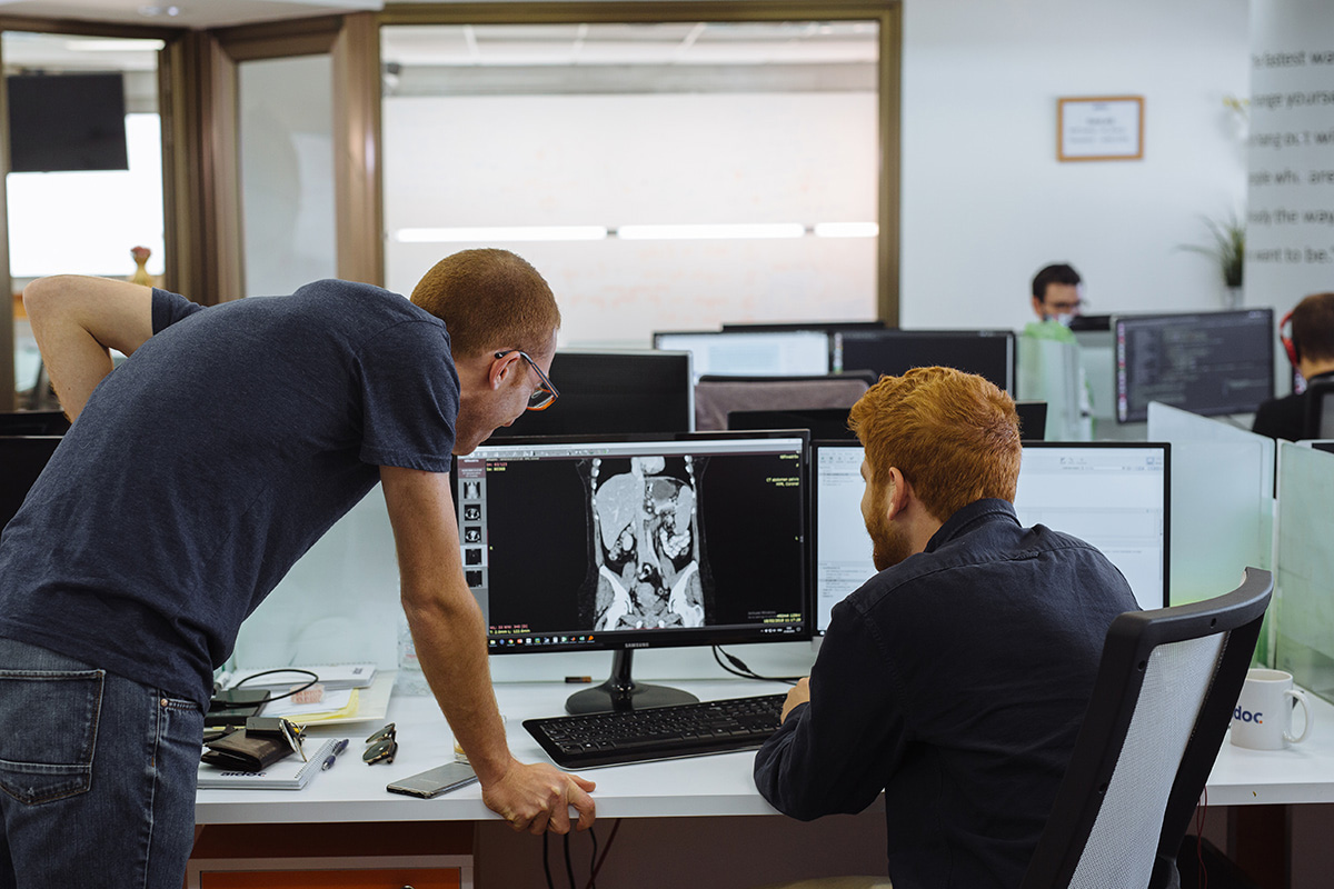 Two men analyzing an CT scan image