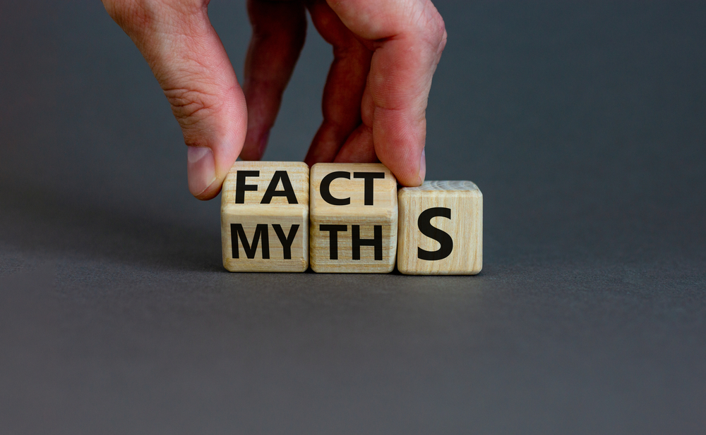 Persons hand holding wooden cubes with letters on them spelling out facts and myths